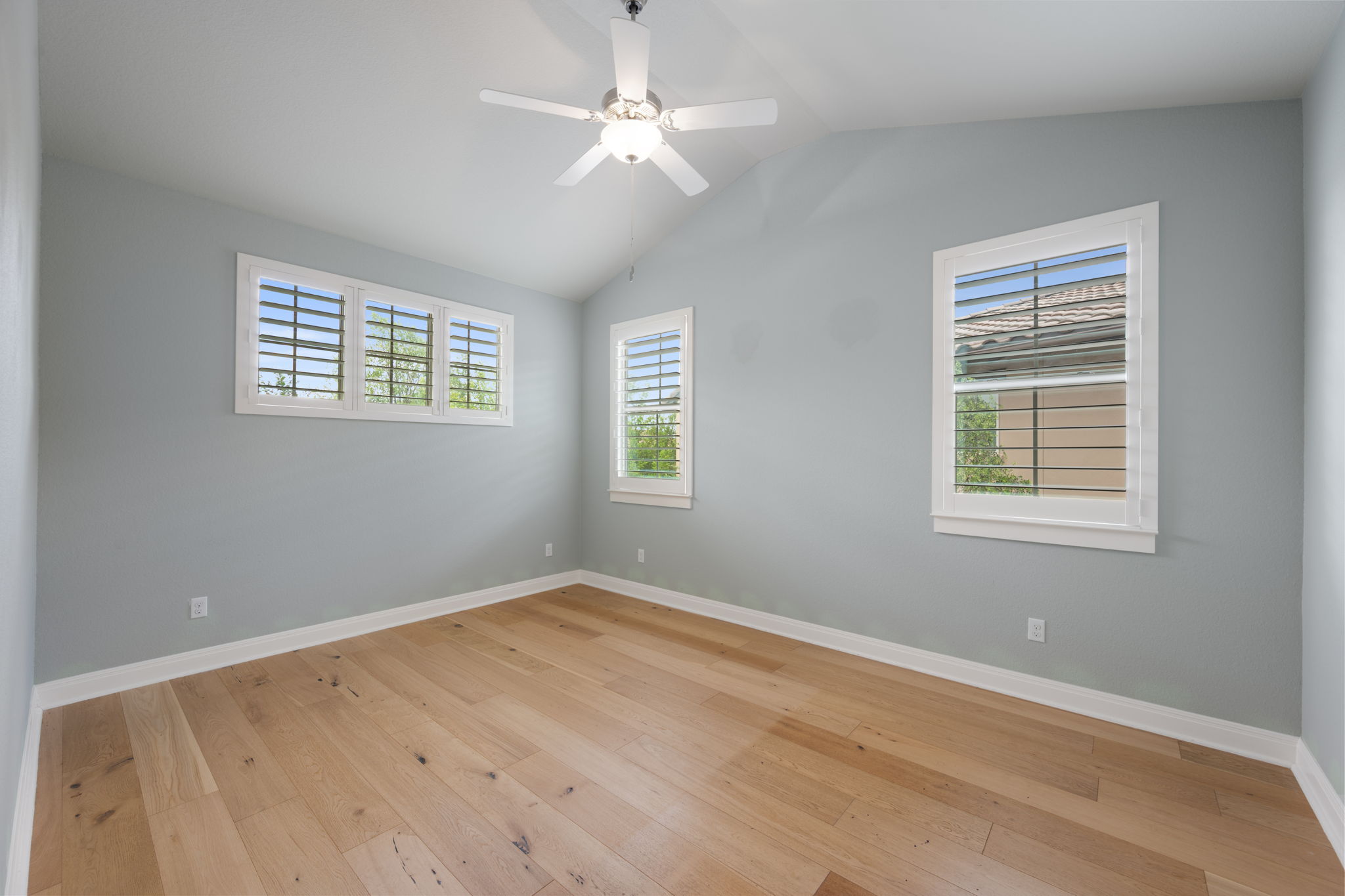 13708 Golden Wave Loop Austin, TX 78738 - Photo 25 of 34 This room features hardwood flooring, light-colored walls, and a vaulted ceiling with a ceiling fan