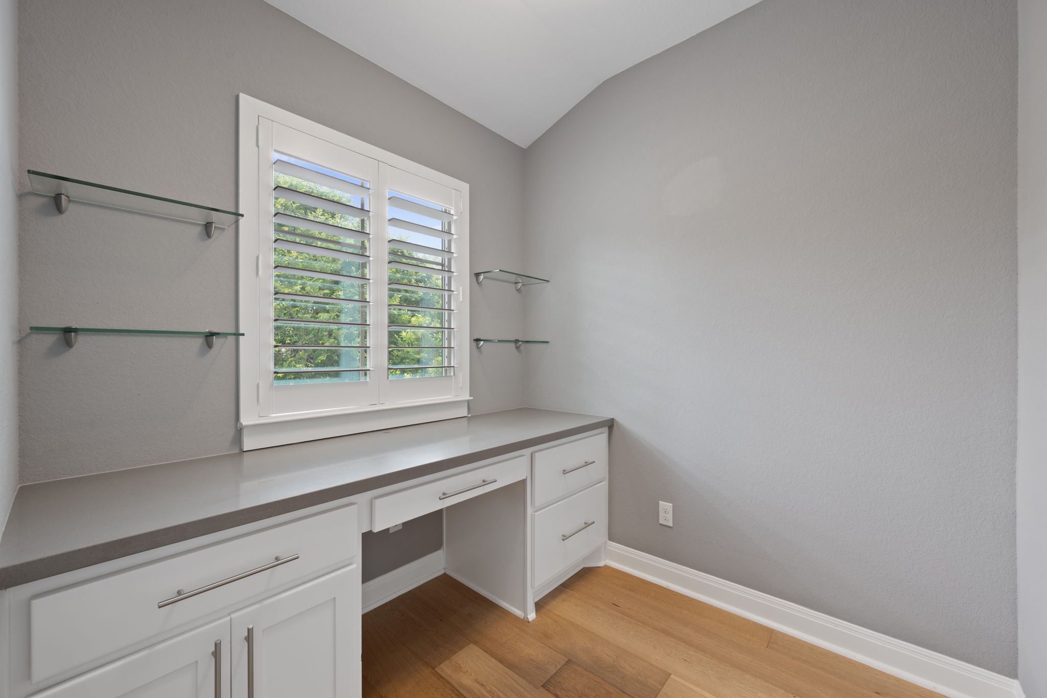 13708 Golden Wave Loop Austin, TX 78738 - Photo 29 of 34 The property features a dedicated workspace with a built-in desk, white cabinetry, and a light-colored countertop