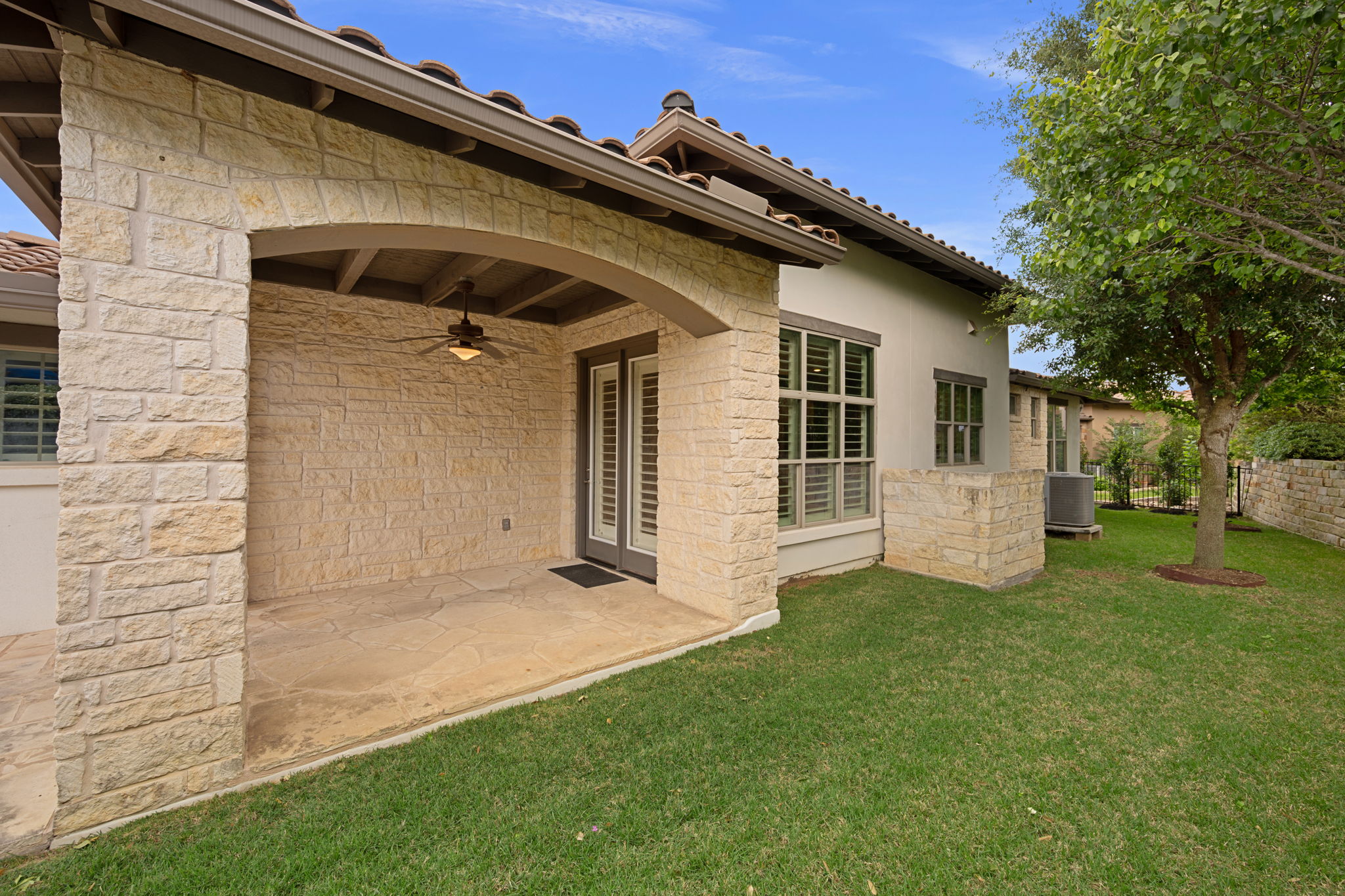 13708 Golden Wave Loop Austin, TX 78738 - Photo 32 of 34 The property features a covered patio with an overhead fan, French doors, and a stone exterior