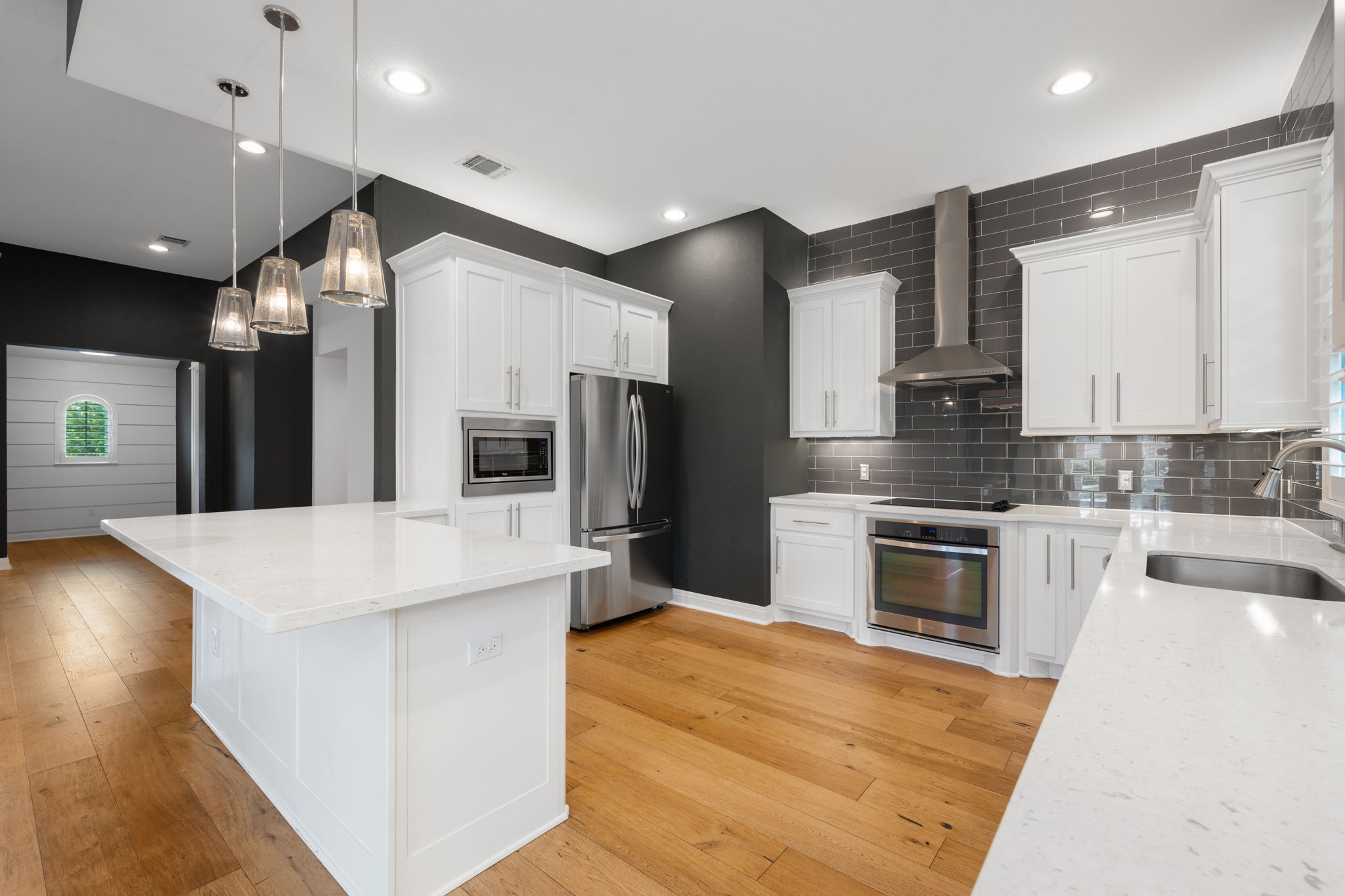 13708 Golden Wave Loop Austin, TX 78738 - Photo 7 of 34 The kitchen features hardwood floors, white cabinetry, and stainless steel appliances