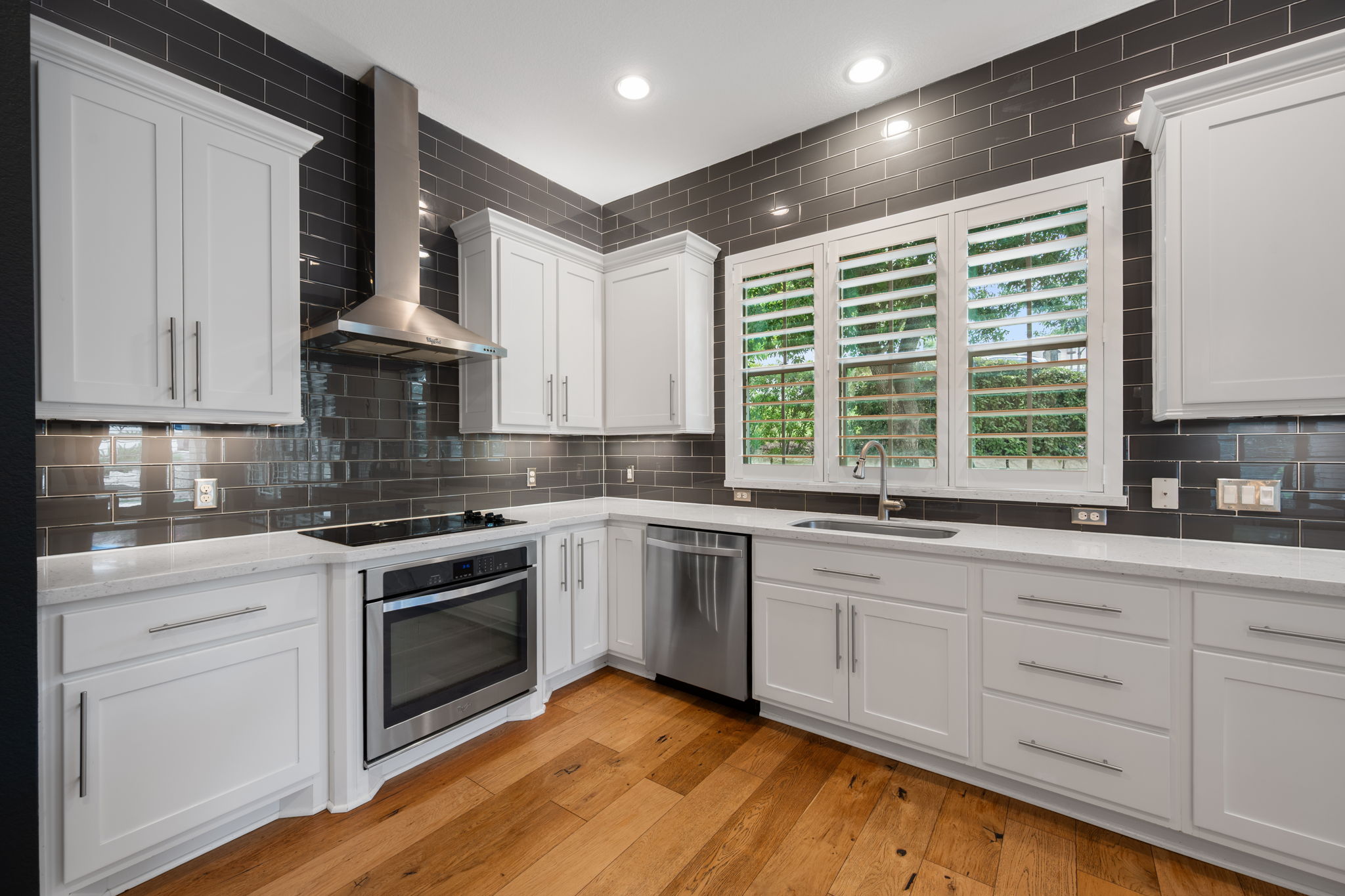 13708 Golden Wave Loop Austin, TX 78738 - Photo 9 of 34 The kitchen features white cabinetry, stainless steel appliances, and a dark subway tile backsplash