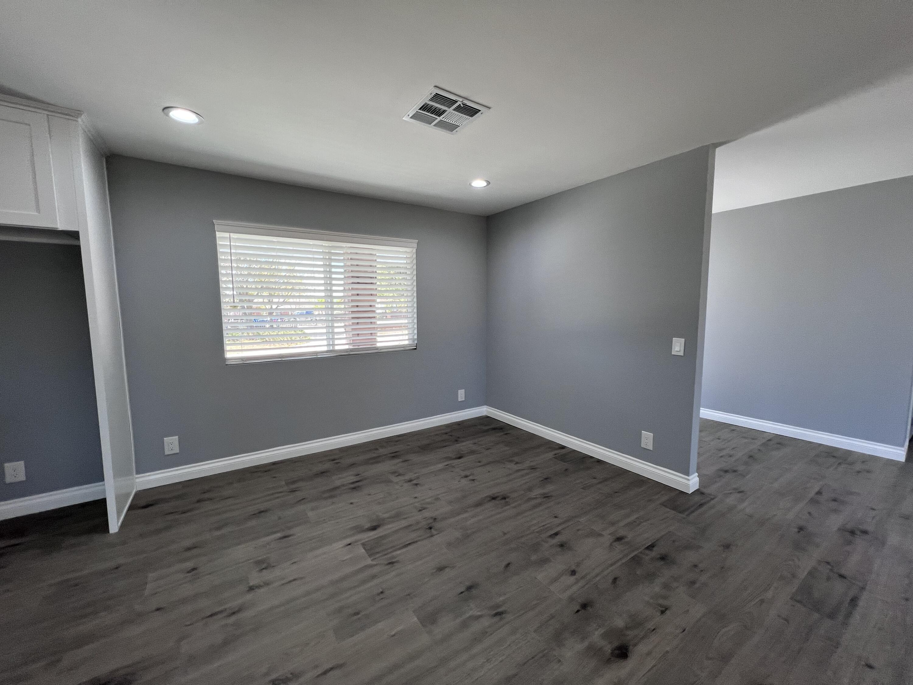 3255 East E Avenue Lancaster, CA 93535 - Photo 23 of 81 an empty room with wooden floor and windows