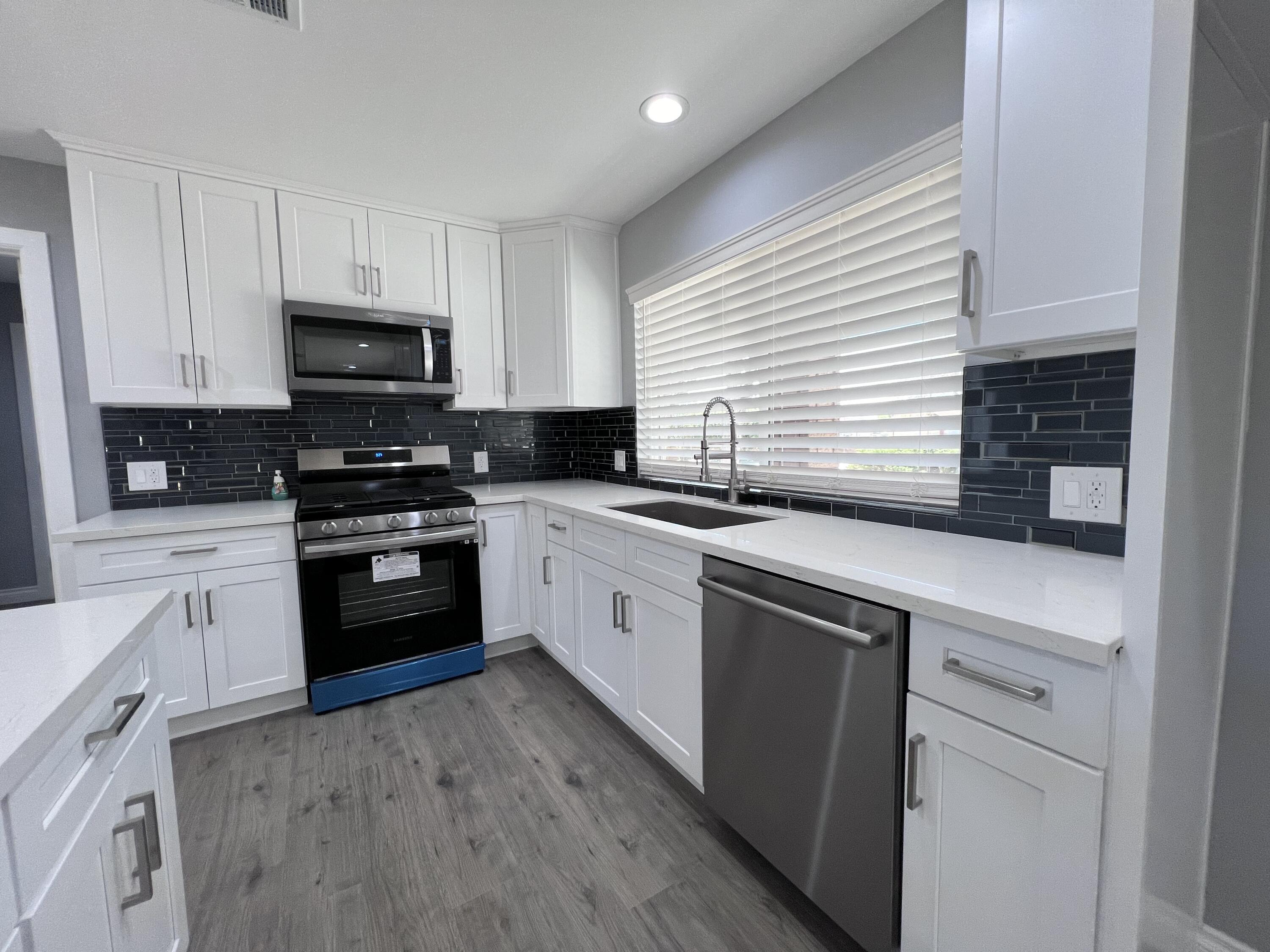3255 East E Avenue Lancaster, CA 93535 - Photo 28 of 81 a kitchen with granite countertop a sink stainless steel appliances and cabinets