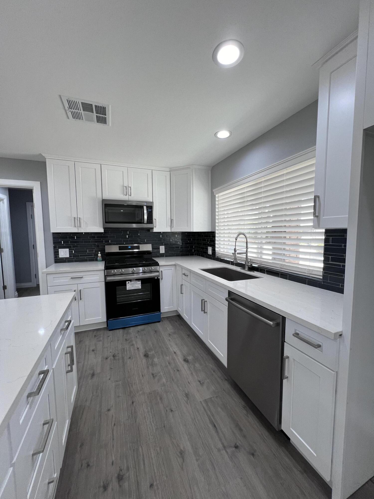 3255 East E Avenue Lancaster, CA 93535 - Photo 29 of 81 a kitchen with kitchen island granite countertop a sink a counter top space stainless steel appliances and cabinets