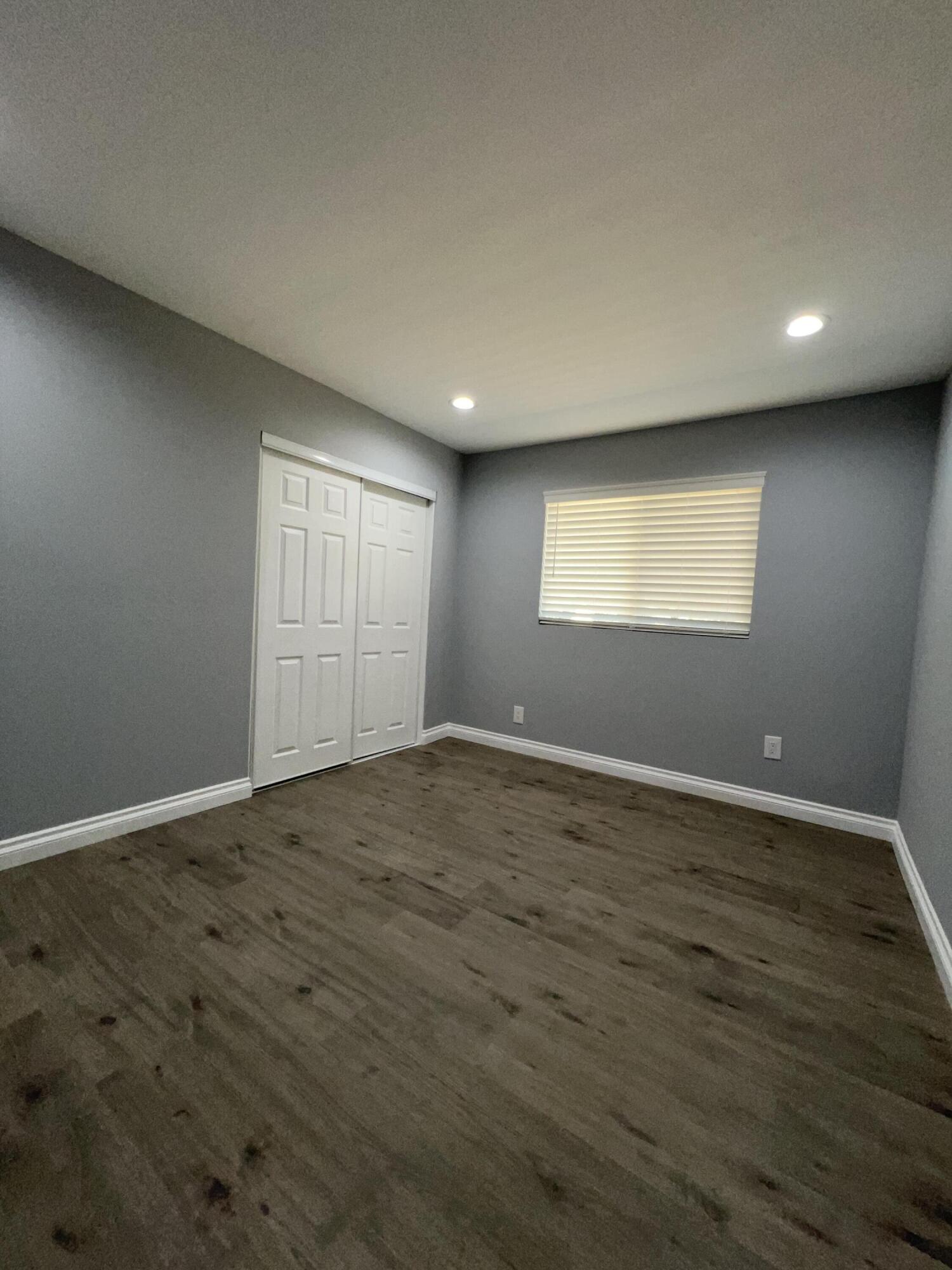 3255 East E Avenue Lancaster, CA 93535 - Photo 45 of 81 an empty room with wooden floor and windows