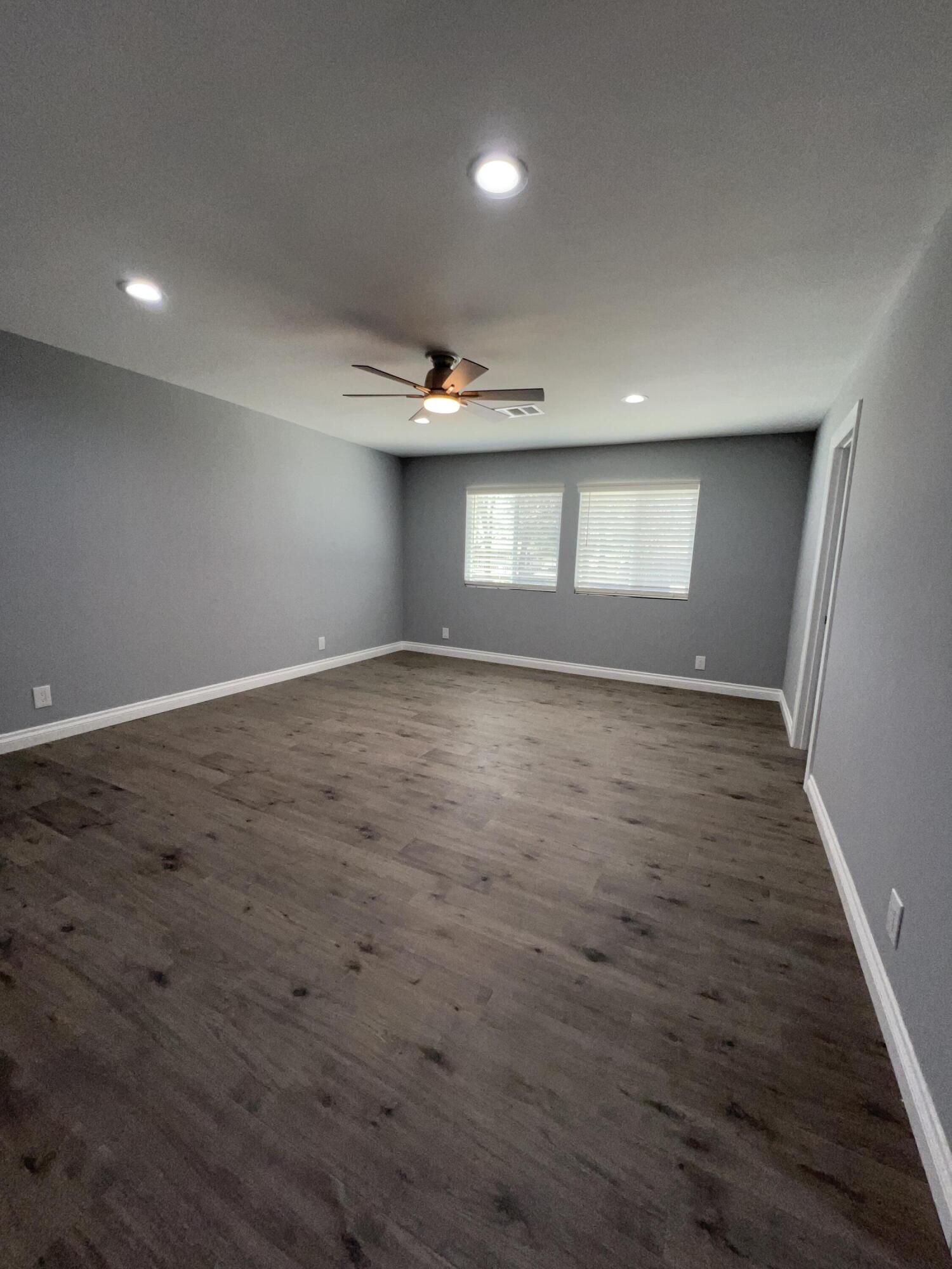 3255 East E Avenue Lancaster, CA 93535 - Photo 53 of 81 an empty room with wooden floor and windows