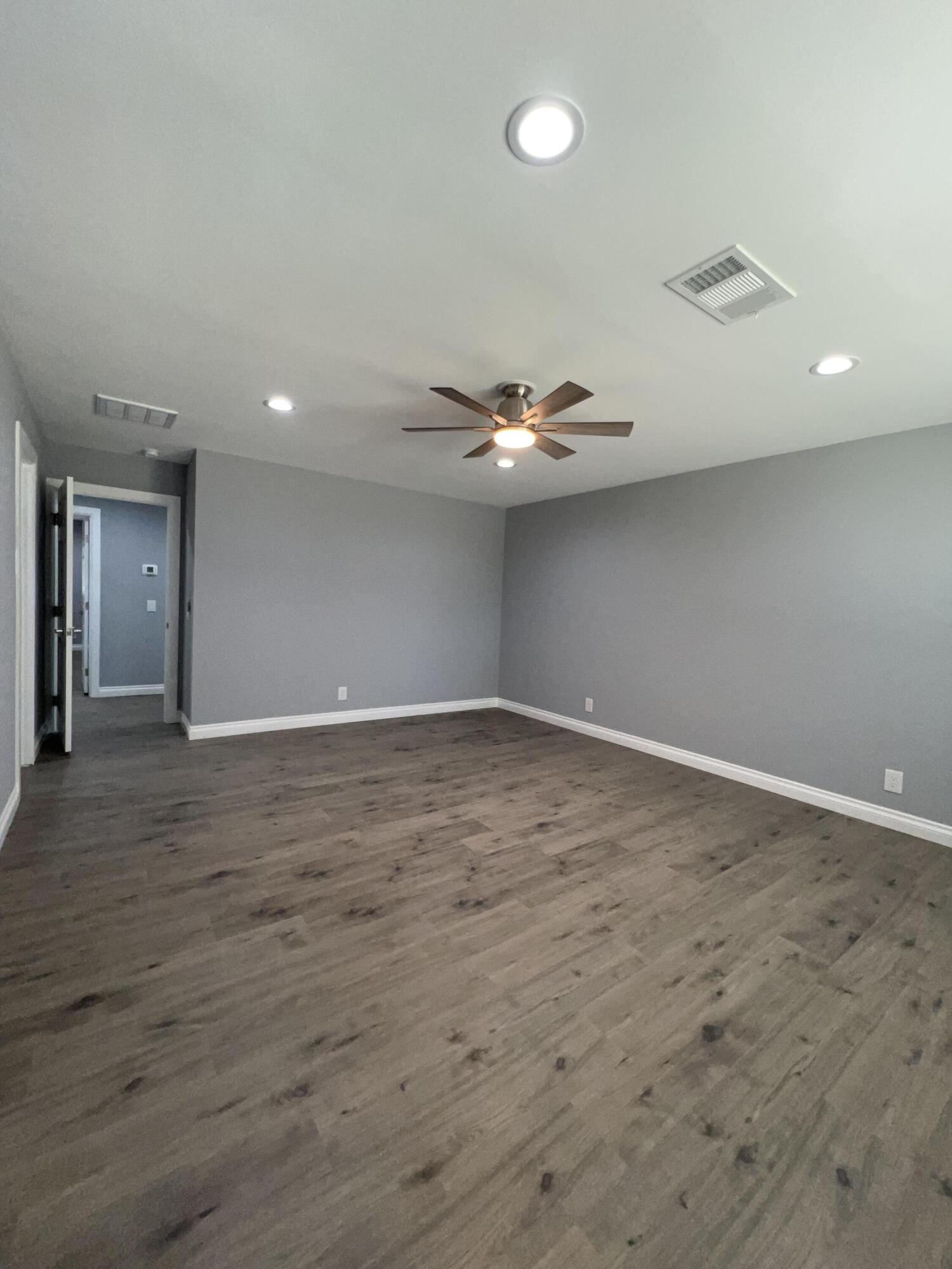 3255 East E Avenue Lancaster, CA 93535 - Photo 54 of 81 a view of an empty room with wooden floor and chandelier