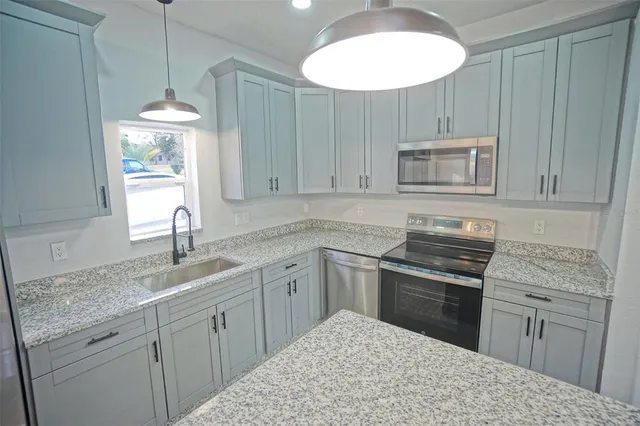 a kitchen with kitchen island a sink stainless steel appliances and cabinets