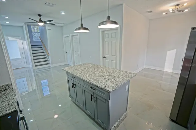 a bathroom with a granite countertop sink a toilet a large mirror and shower