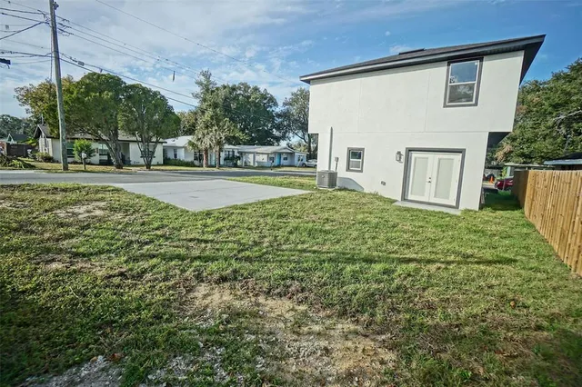 a view of a house with backyard and a tree