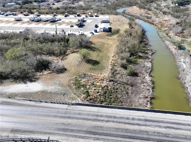 a view of a wooden floor with a yard and large trees