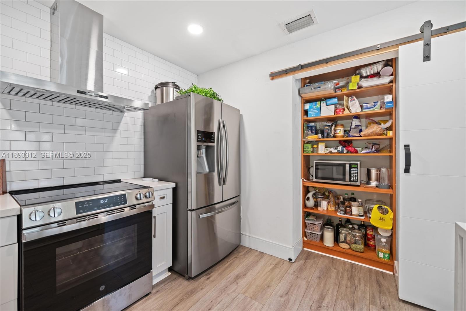 139 Southwest 159th Way Sunrise, FL 33326 - Photo 17 of 40 a kitchen with stainless steel appliances and a wooden floor