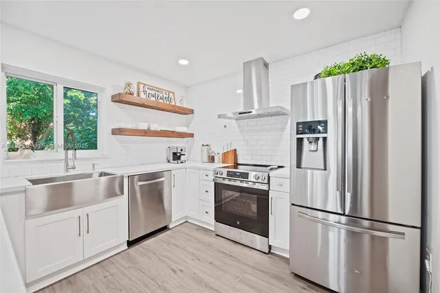 a kitchen with stainless steel appliances a refrigerator sink and microwave