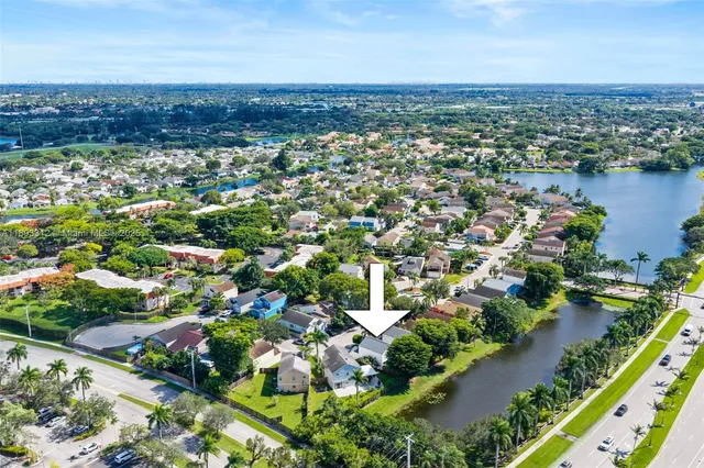 an aerial view of residential houses with outdoor space and trees