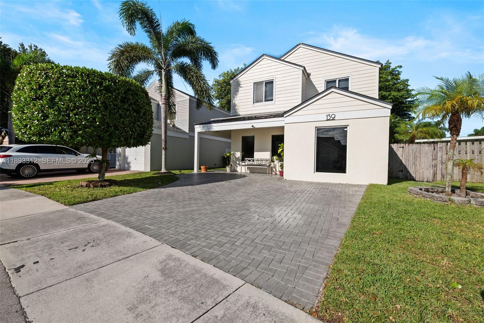 139 Southwest 159th Way Sunrise, FL 33326 - Photo 7 of 40 a view of a white house with a yard and potted plants