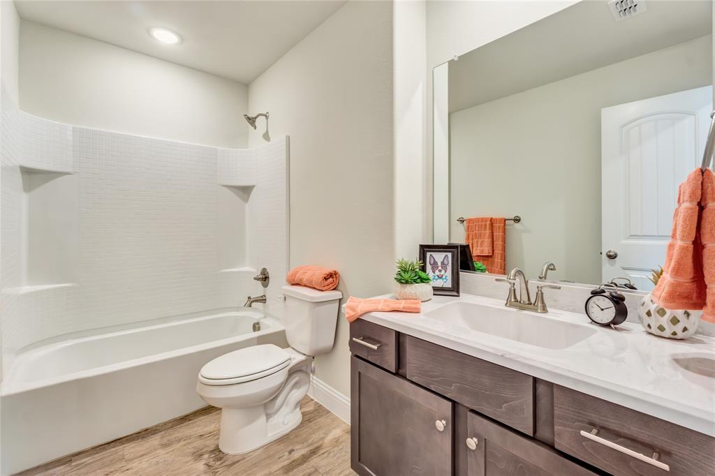 4713 Enclave Drive Sanger, TX 76266 - Photo 11 of 12 a bathroom with a sink a toilet and a mirror