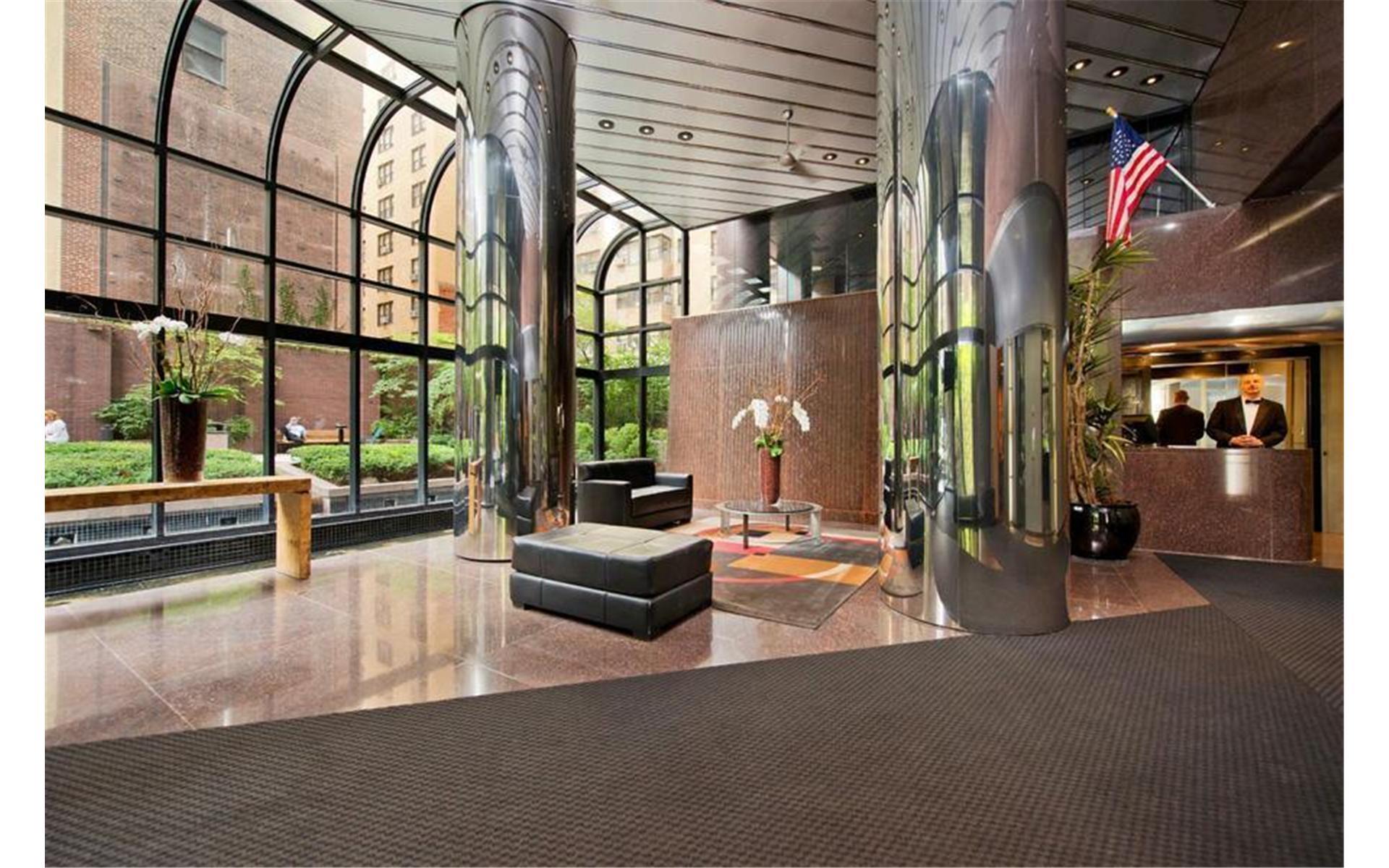 415 East 54th Street, Unit 25GG Manhattan, NY 10022 - Photo 21 of 30 a lobby with furniture and floor to ceiling window