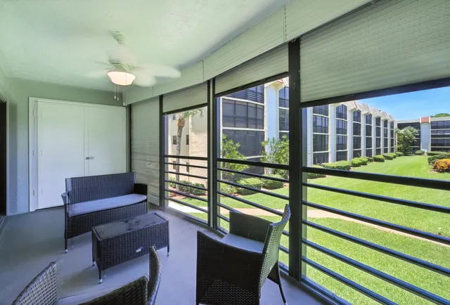 a view of a porch with furniture and a yard