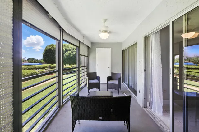a dining room with furniture and a floor to ceiling window