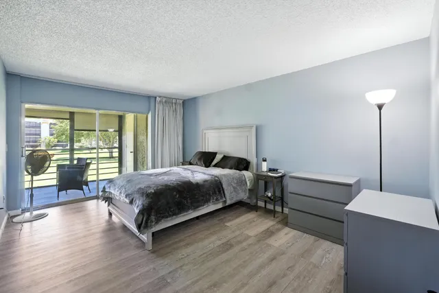 a bedroom with a bed and large wooden floor