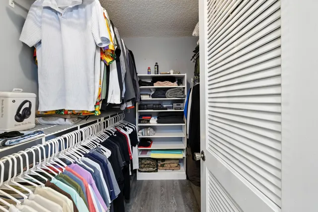 a view of walk in closet with clothes and shoes