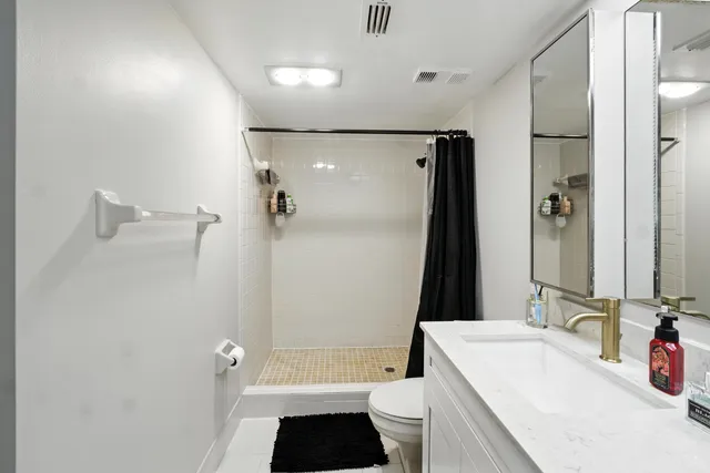 a bathroom with a tub sink toilet and a mirror