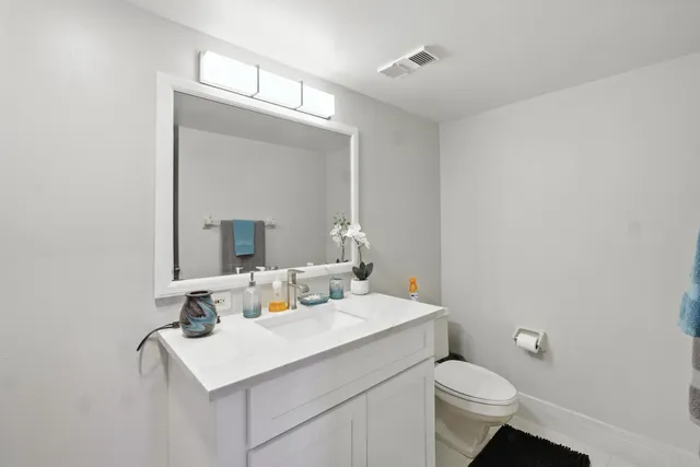 a bathroom with a sink mirror and toilet