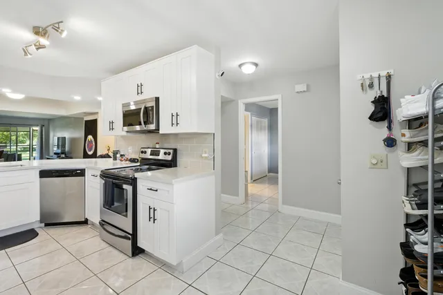 a kitchen with stainless steel appliances granite countertop a refrigerator and a stove top oven