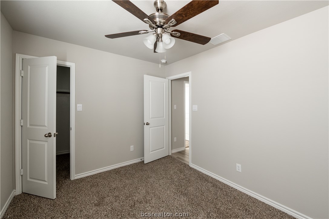 2159 Chief Street Bryan, TX 77807 - Photo 11 of 22 an empty room with a chandelier fan and windows