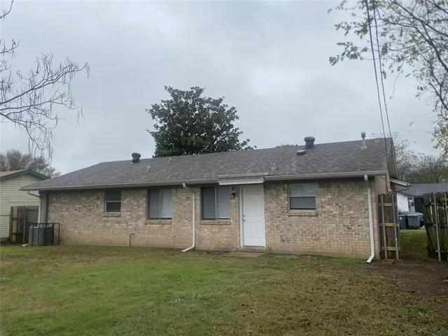 a view of a stone house with a big yard