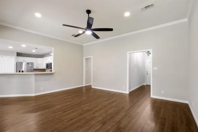 a view of empty room with wooden floor and window