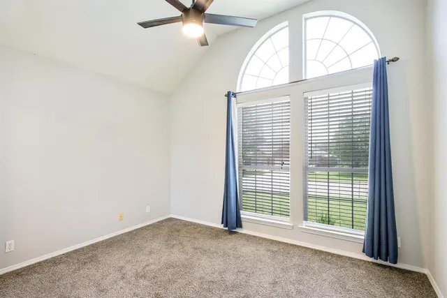 an empty room with a window and a ceiling fan