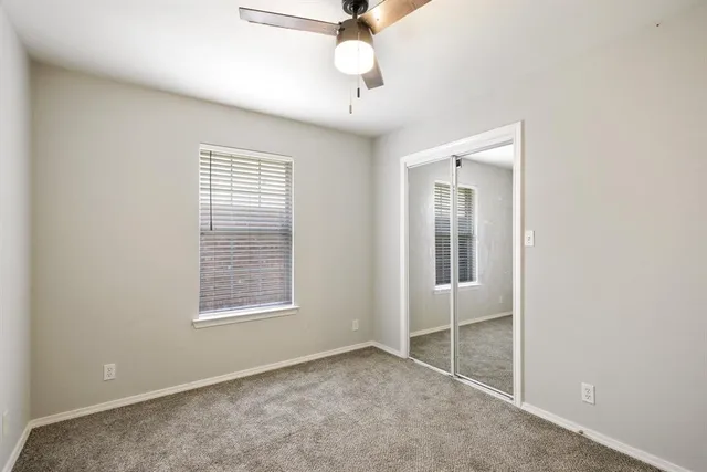 an empty room with fan and windows