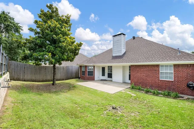 a backyard of a house with table and chairs