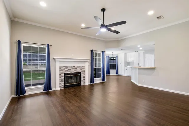 an empty room with wooden floor a fireplace and windows