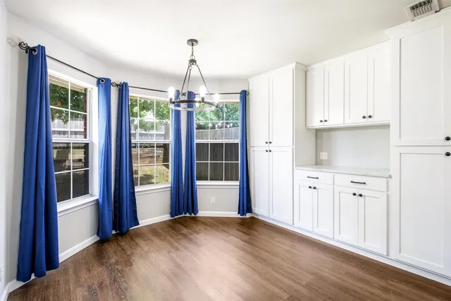 a view of a kitchen with refrigerator and wooden floor
