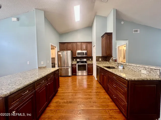 a bathroom with a sink a toilet a mirror and shower