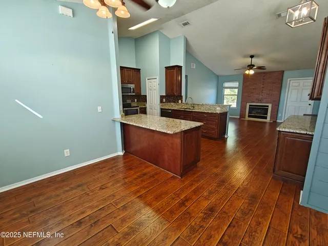 a large kitchen with stainless steel appliances kitchen island granite countertop a large counter top and stove
