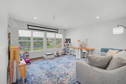 a living room with furniture and a floor to ceiling window