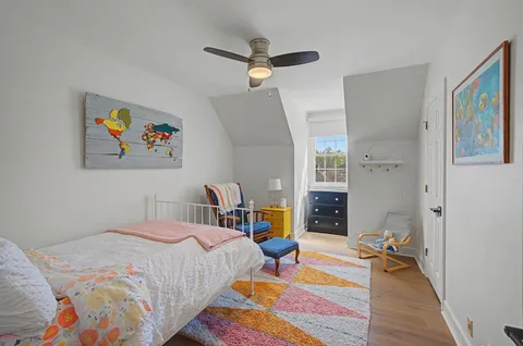 a bedroom with a bed and painting on the wall