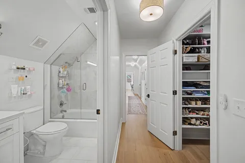 a view of walk in closet with clothes and shoes