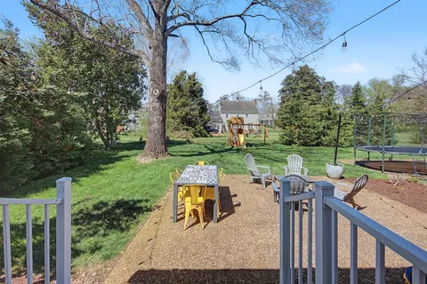 a view of backyard with seating space and trees