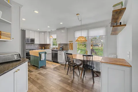 a kitchen with a table chairs sink and cabinets
