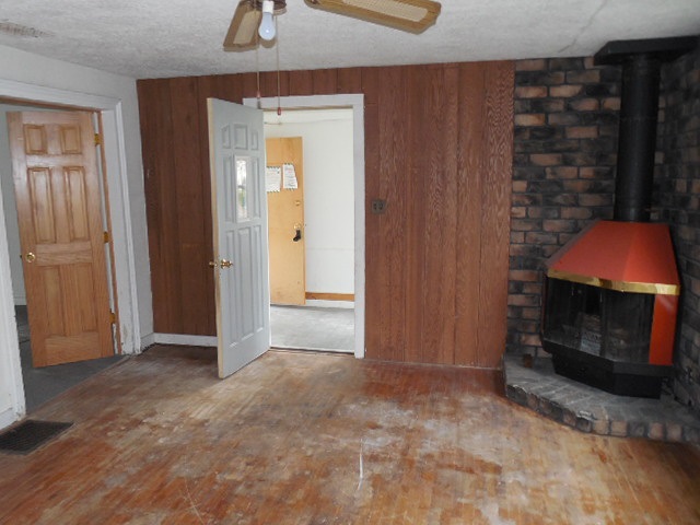 206 Adams Street Ridott, IL 61067 - Photo 3 of 8 a view of an empty room with wooden floor and a fireplace