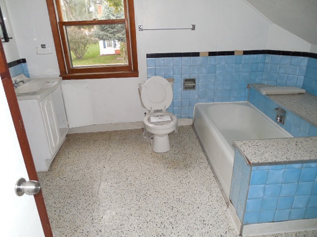 206 Adams Street Ridott, IL 61067 - Photo 6 of 8 a bathroom with a granite countertop sink toilet and a bathtub