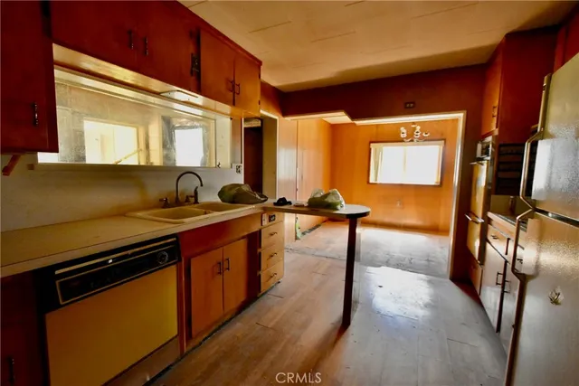 a kitchen with stainless steel appliances granite countertop a sink a stove and a refrigerator