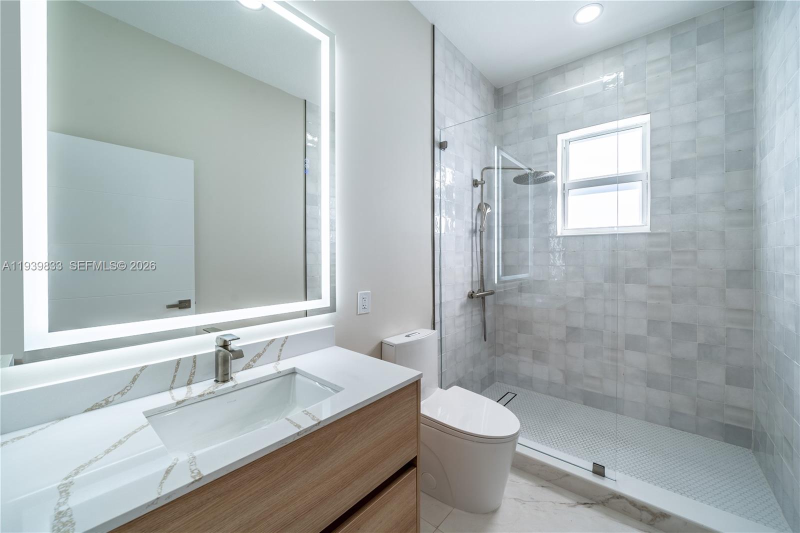 8041 Bermuda Point Lane Davie, FL 33328 - Photo 19 of 60 a bathroom with a granite countertop sink toilet and shower