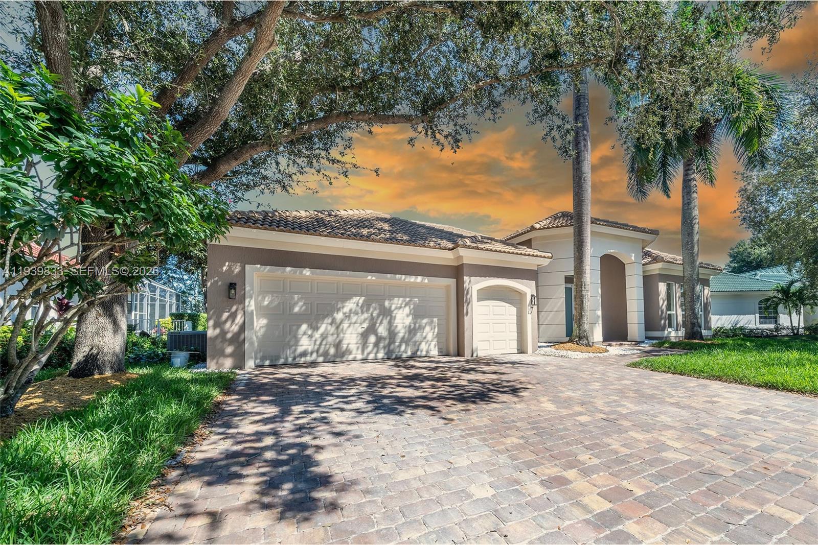 8041 Bermuda Point Lane Davie, FL 33328 - Photo 2 of 60 a front view of a house with a garden and trees