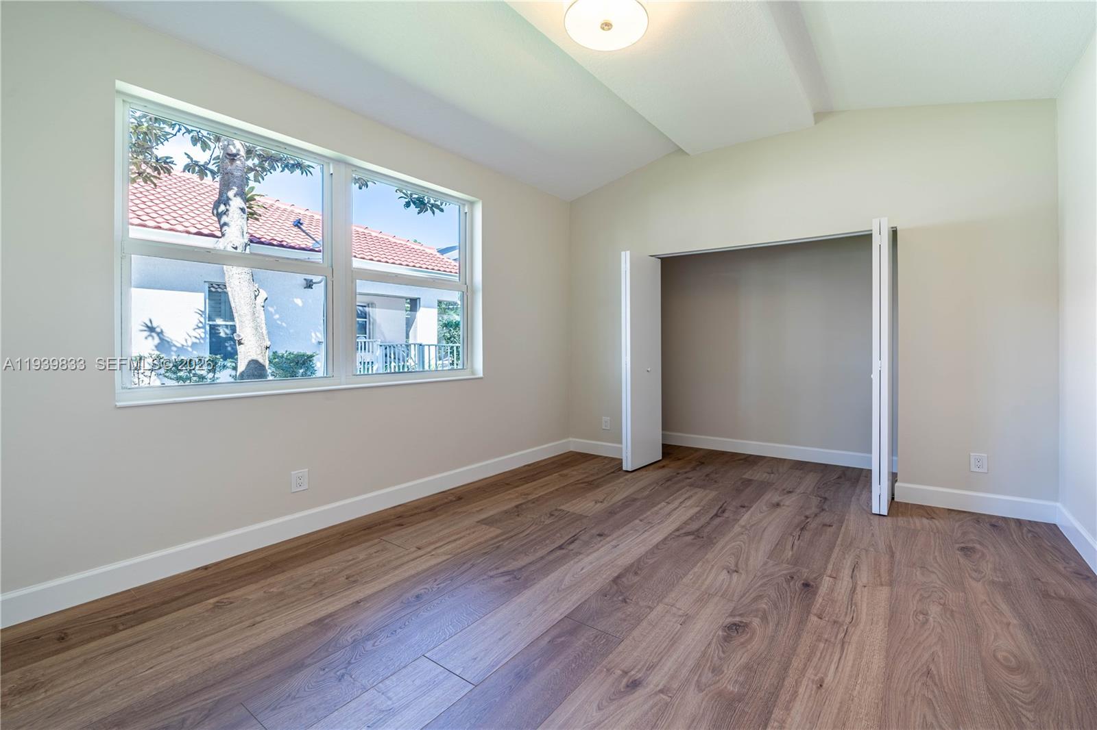 8041 Bermuda Point Lane Davie, FL 33328 - Photo 31 of 60 an empty room with wooden floor ceiling fan and windows
