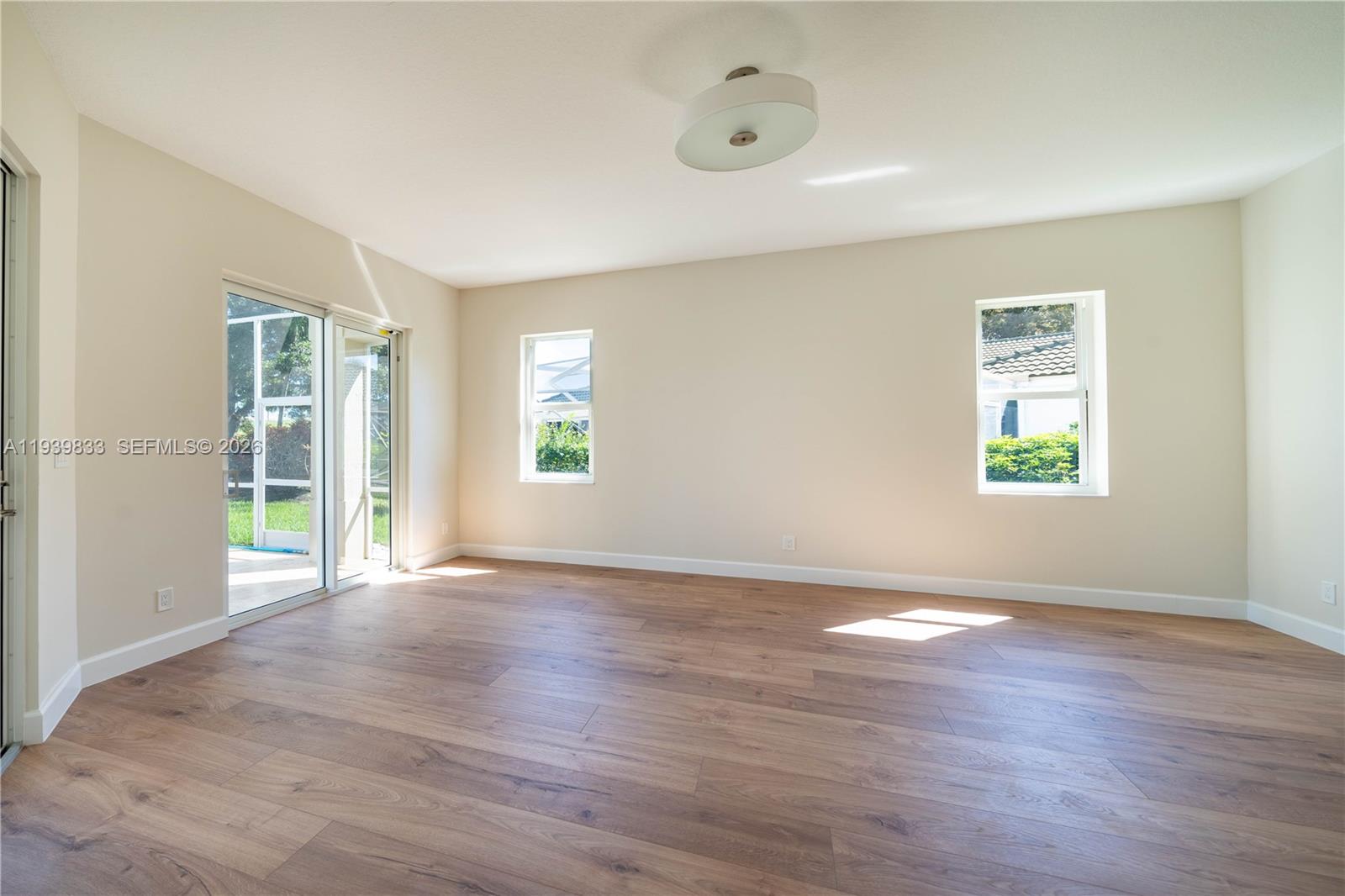 8041 Bermuda Point Lane Davie, FL 33328 - Photo 33 of 60 an empty room with wooden floor and windows